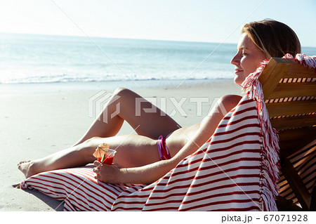 Woman enjoying cocktail at the beach 67071928