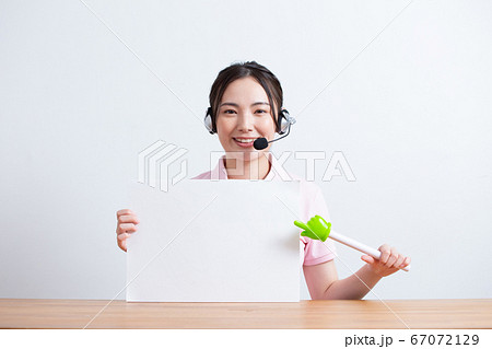 ヘッドセットを付けてコピーボードを持つ女性 67072129