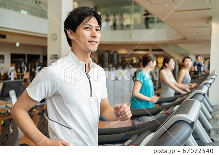 ジムのランニングマシンで走る男性 67072540