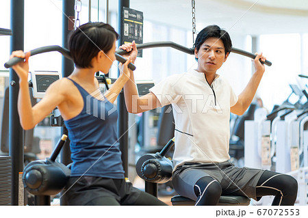 ジムで筋トレするカップルの写真素材