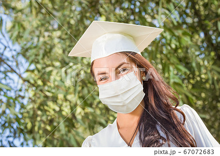 Female Graduate in Cap and Gown Wearing Medical Face Mask 67072683