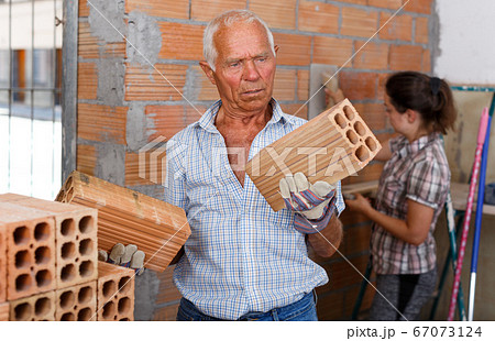 Man with daughter working with red brick Man with daughter working with red brick 67073124