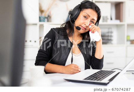 Frustrated woman customer support phone operator at workplace Frustrated woman customer support phone operator at workplace 67074287