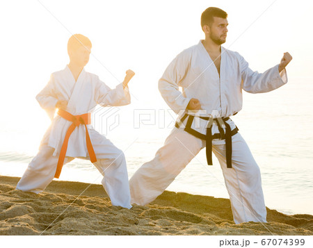 Teacher and boy doing karate poses Teacher and boy doing karate poses 67074399