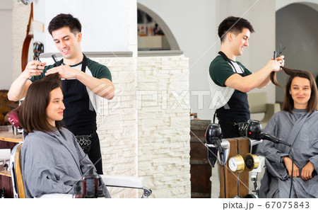 Man professional hairdresser cut female's hair in salon 67075843
