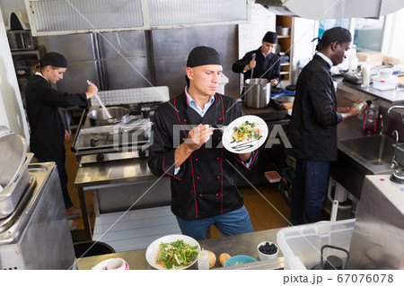 Chef with team preparing food Chef with team preparing food 67076078