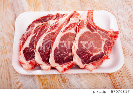 Plastic tray with raw pork chops on bone Plastic tray with raw pork chops on bone 67076317