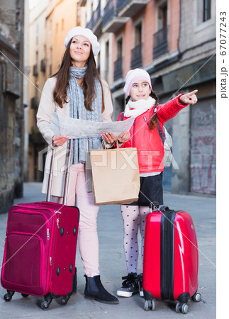 Cheerful girl and woman with map in scarf 67077243
