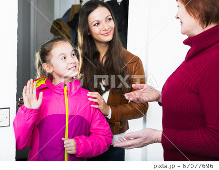 Girl with mother visiting her grandmother Girl with mother visiting her grandmother 67077696
