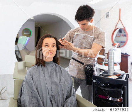 Young guy professional hairdresser cut woman's hair Young guy professional hairdresser cut woman's hair 67077935