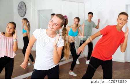 Teenage girl practicing dance with group 67078830