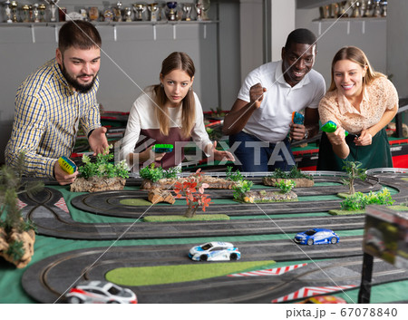 Racing car on the toy race track and team players Racing car on the toy race track and team players 67078840