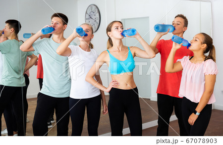 Teens drinking water on break during dancing training 67078903