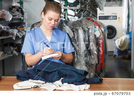 Worker of laundry writing receipt Worker of laundry writing receipt 67079703