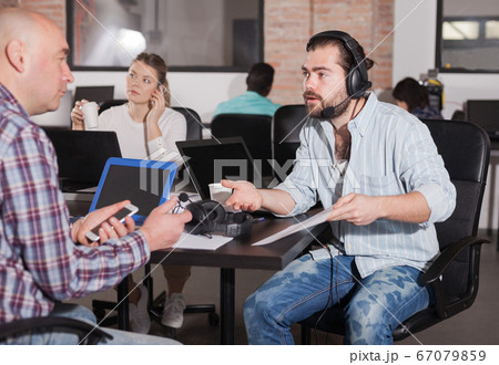 Hispanic manager consulting male client Hispanic manager consulting male client 67079859