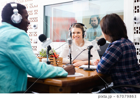 Multinational group of cheerful young adults emotionally discussing in radio studio 67079863