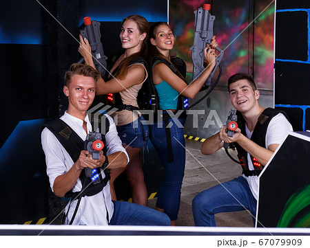 happy girls and guys in dark laser tag room happy girls and guys in dark laser tag room 67079909