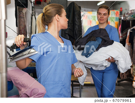 Girl ironing clothes after dry cleaning Girl ironing clothes after dry cleaning 67079961