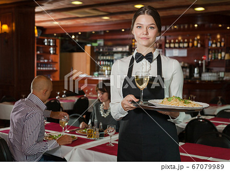 Smiling waitress with serving tray Smiling waitress with serving tray 67079989