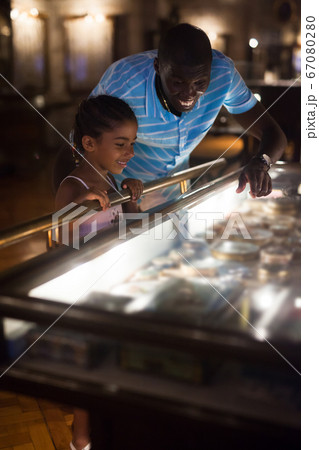 Man and his daughter looking at showcase with exhibits Man and his daughter looking at showcase with exhibits 67080280