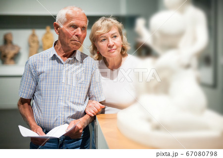 Couple holding brochure at museum Couple holding brochure at museum 67080798