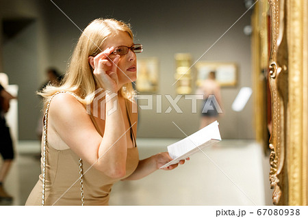Woman holding brochure in museum of arts 67080938