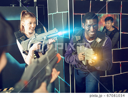 Modern people of different nationalities with laser pistols play Modern people of different nationalities with laser pistols play 67081034