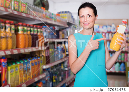 Female in the supermarket holding juice in bottle Female in the supermarket holding juice in bottle 67081478