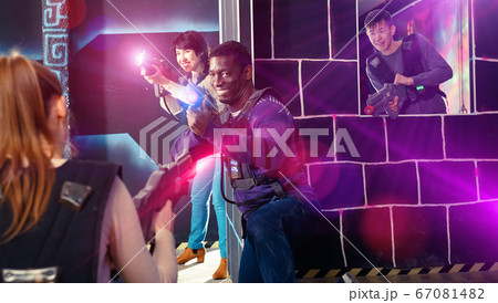 Modern people of different nationalities with laser pistols play Modern people of different nationalities with laser pistols play 67081482