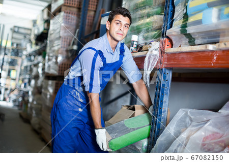 calm male in uniform is choosing cement in the building store 67082150