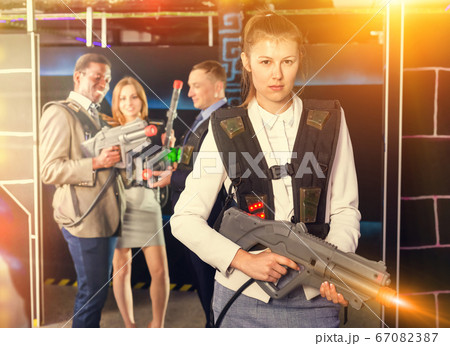 Woman holding laser gun and playing laser tag Woman holding laser gun and playing laser tag 67082387