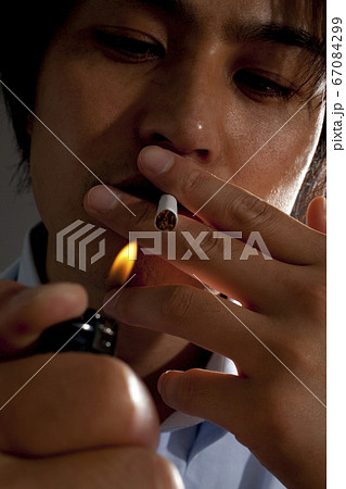 タバコに火をつける男性の写真素材