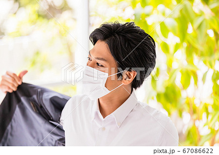 マスクをつけた若い男性(上着を着る・脱ぐ) マスクをつけた若い男性(上着を着る・脱ぐ) 67086622