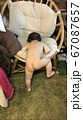 裸の赤ちゃんが椅子に登ろうとしている後ろ姿 67087657