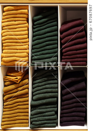 Shelves with evenly folded pullovers in different colors Shelves with evenly folded pullovers in different colors 67087697