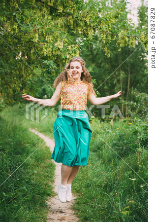 Young Pretty Plus Size Caucasian Happy Smiling Laughing Girl Woman Jumping In Summer Green Forest. Fun Enjoy Outdoor Summer Nature. 67087829