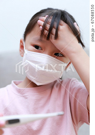 マスクをして体温を測る体調不良の乳幼児 67088550