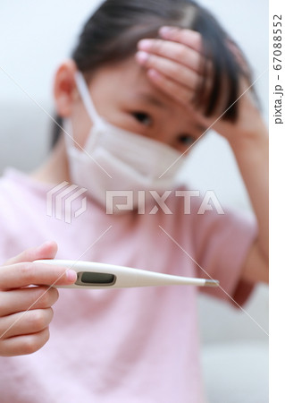 マスクをして体温を測る体調不良の乳幼児 67088552