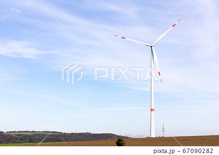 A windmill on a field with blue sky 67090282