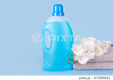 Bottle of detergent with clean towels and flowers 67090691