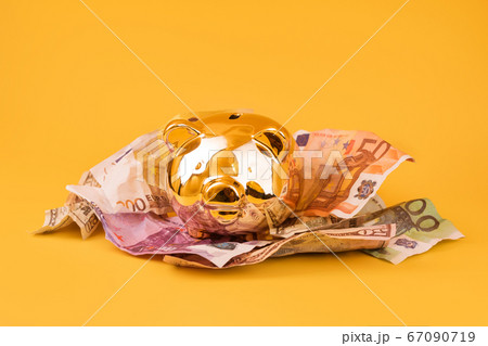 Golden piggy bank with cash money, euro and dollar 67090719