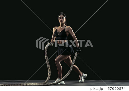 Beautiful young female athlete practicing on black studio background, full length portrait Beautiful young female athlete practicing on black studio background, full length portrait 67090874