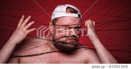 Fat man tangled in black threads on red background Fat man tangled in black threads on red background 67091409