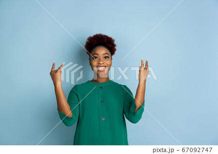 African-american beautiful young woman's portrait on blue studio background, emotional and expressive. Copyspace for ad. 67092747