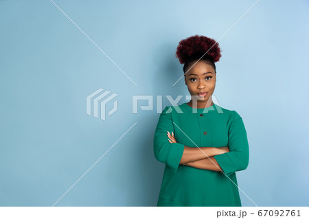 African-american beautiful young woman's portrait on blue studio background, emotional and expressive. Copyspace for ad. African-american beautiful young woman's portrait on blue studio background, emotional and expressive. Copyspace for ad. 67092761