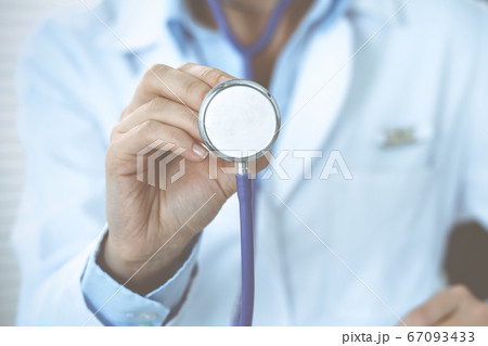 Unknown doctor woman holds stethoscope head, close-up. Physician ready to examine and help patient. Helping and insurance in health care, best treatment and medicine concept 67093433