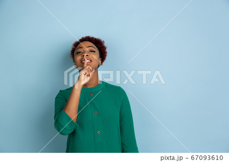African-american beautiful young woman's portrait on blue studio background, emotional and expressive. Copyspace for ad. 67093610