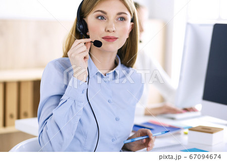 Portrait of call center operator at work. Group of people in a headset ready to help customers. Business concept 67094674