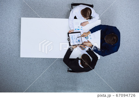 Group of business people analyzing financial documents, view from above. Business team at meeting Group of business people analyzing financial documents, view from above. Business team at meeting 67094726
