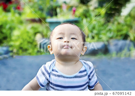 外で遊んで自慢げな陶酔したような表情をしている子供　水遊びしてずぶ濡れの子供 67095142